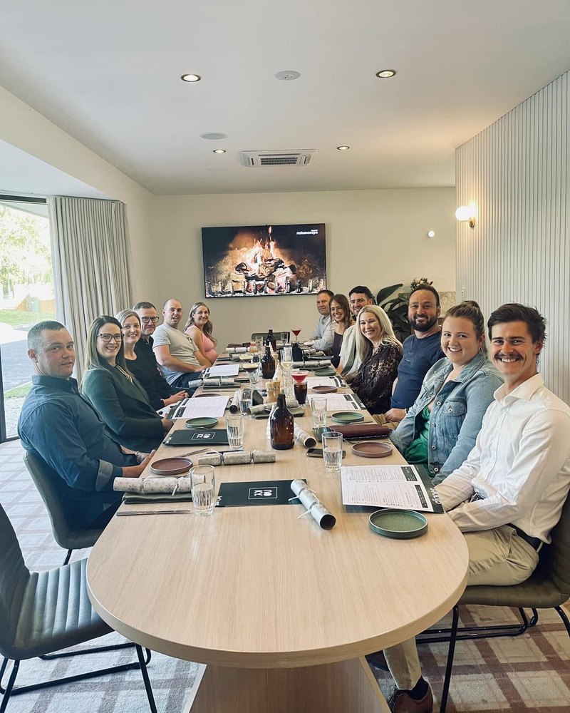 The Mustart team around a long table at lunch